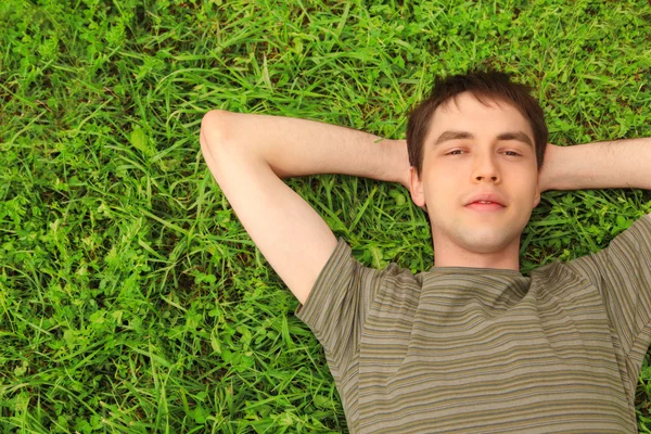 Teenager lies on grass — Stock Photo, Image