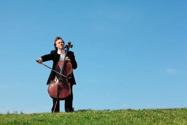 Музикант грає на віолончелі проти неба — стокове фото