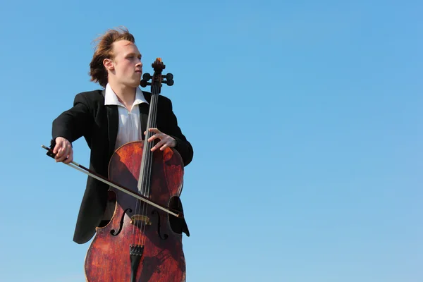Musicien joue du violoncelle contre le ciel — Photo