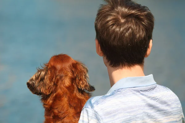 Jovem e seu dachshund de volta ao ar livre contra a água — Fotografia de Stock
