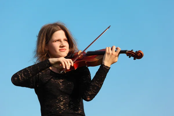 Meisje speelt viool tegen hemel — Stockfoto