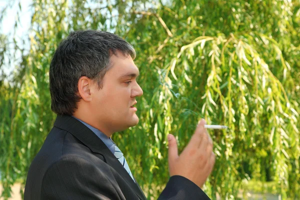 Курение бизнесмен на открытом воздухе летом — стоковое фото