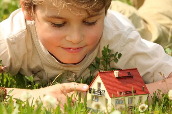 在草丛中的男孩和房子模型 — 图库照片