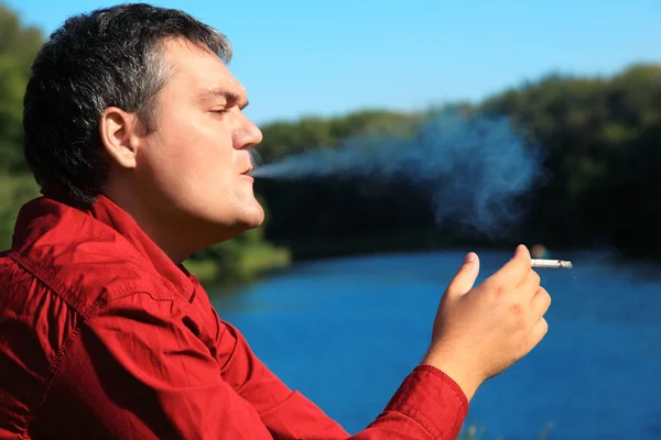 Κάπνισμα άνθρωπος στην όχθη ποταμού — Φωτογραφία Αρχείου
