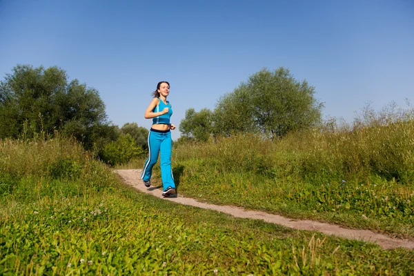 Giovane donna attraente corre nel paese — Foto Stock