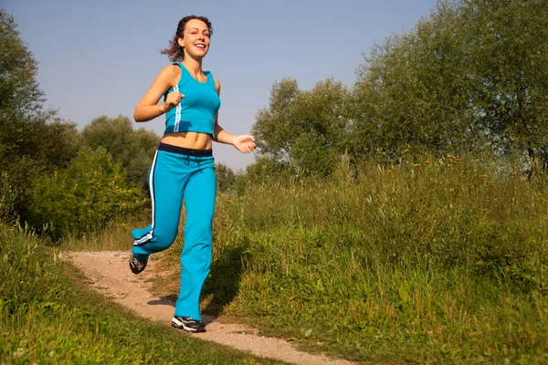 Young attractive woman runs in the country — Stock Photo, Image