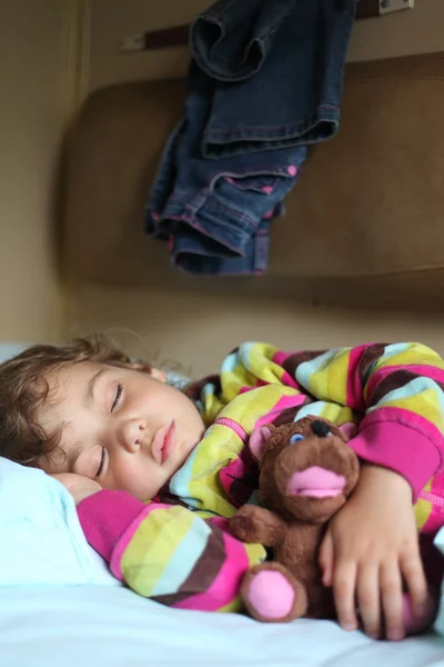 Девочка спит в поезде с куклой — стоковое фото