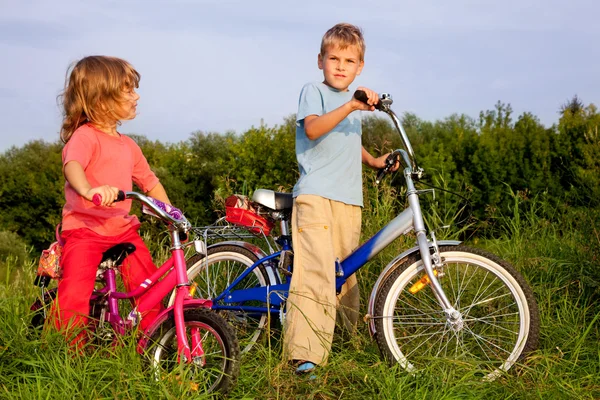 Young bikers rest in the field — Stock Photo, Image