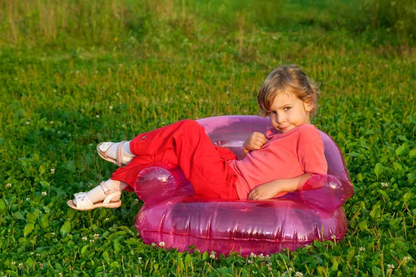 Modelo jovem senta-se na poltrona inflável ao ar livre — Fotografia de Stock