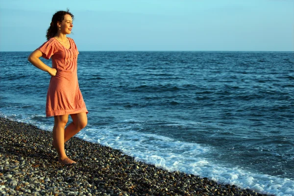 Νεαρή γυναίκα να στέκεται στην ξηρά της θάλασσας — Φωτογραφία Αρχείου