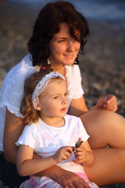 Anne ile kızı sahil üzerinde oturur — Stok fotoğraf