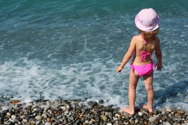Μικρό κορίτσι στέκεται στην παραλία, πίσω όψη — Φωτογραφία Αρχείου