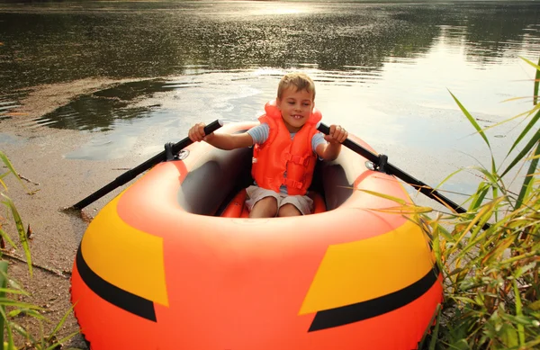 Мальчик в надувной лодке в воде — стоковое фото