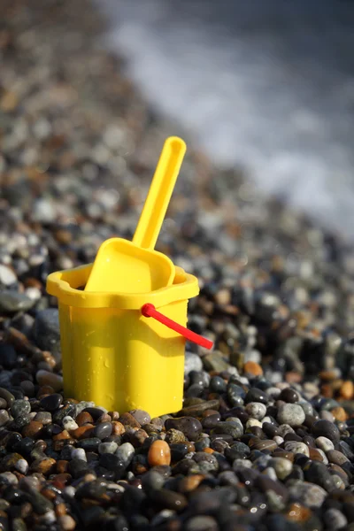 Seau jaune pour enfants avec cuillère sur le littoral — Photo