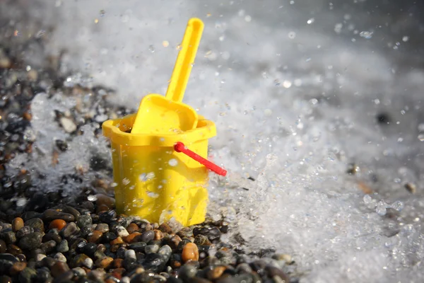 Žlutá dětská kbelík s kopečkem na pobřežní — Stock fotografie