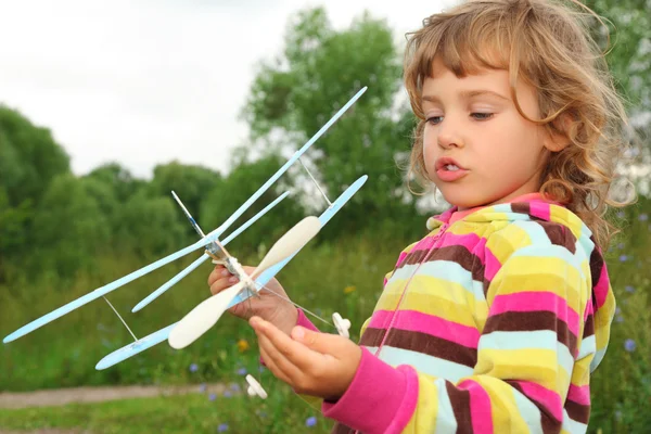 Menina com avião de brinquedo em mãos ao ar livre — Fotografia de Stock