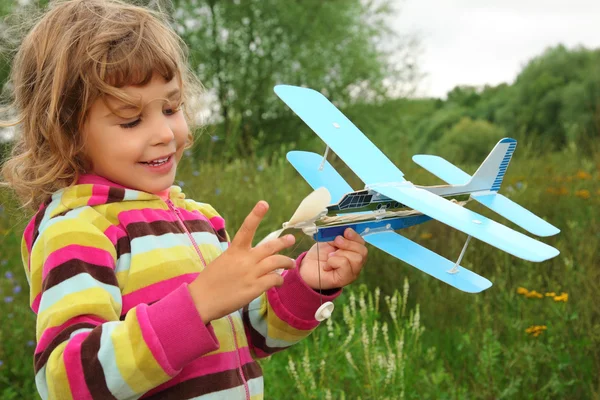 Κοριτσάκι με αεροπλάνο παιχνίδι στα χέρια εξωτερική — Φωτογραφία Αρχείου