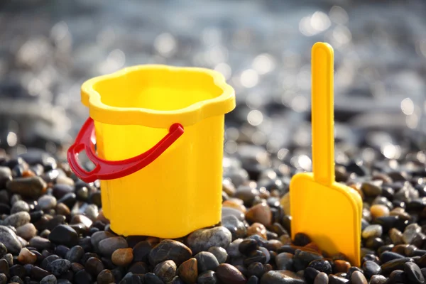 Cubo para niños amarillo con cuchara en la costa —  Fotos de Stock
