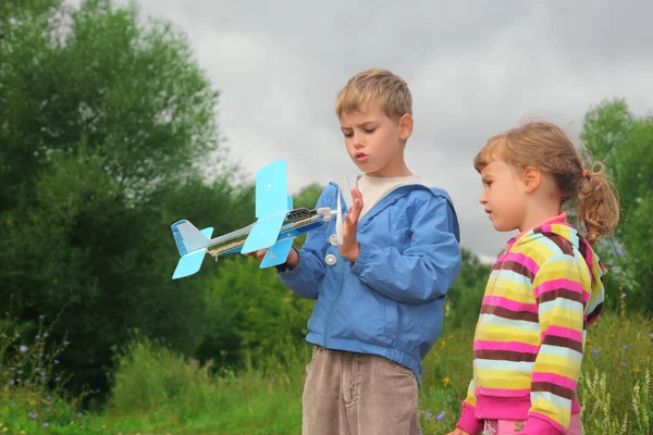 Küçük kız ve erkek ile açık elinde oyuncak uçak — Stok fotoğraf