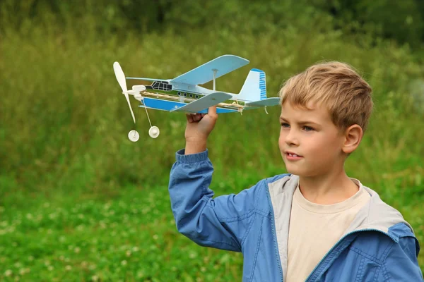 Niño con juguete avión en manos al aire libre — Foto de Stock