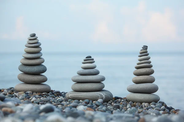 Três pilhas de pedra na praia de seixos — Fotografia de Stock