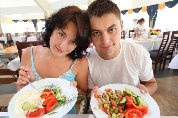 Mladý pár v kavárně s deskami se salátem v rukou — Stock fotografie