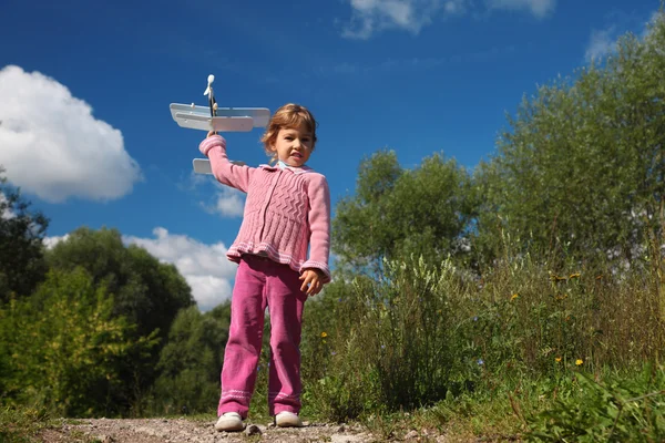 Bambina con aeroplano giocattolo in mano corpo pieno all'aperto — Foto Stock