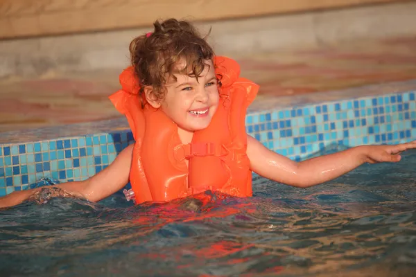 Menina em colete inflável na piscina — Fotografia de Stock