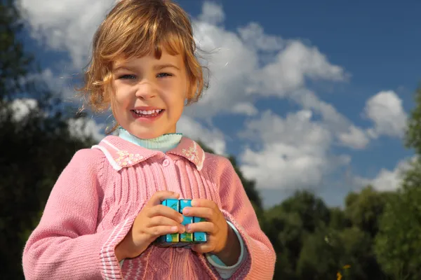 Маленькая девочка с волшебным кубом летом на открытом воздухе — стоковое фото