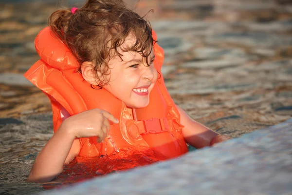 充气背心在游泳池中的小女孩 — 图库照片