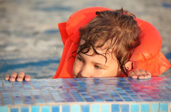 Menina em colete inflável na piscina — Fotografia de Stock