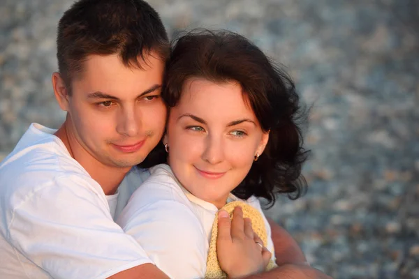 Joven pareja abraza en playa — Foto de Stock