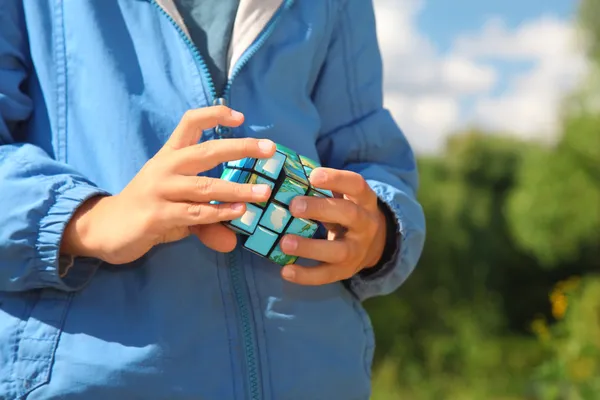 Manos de niño con cubo mágico al aire libre en verano — Foto de Stock