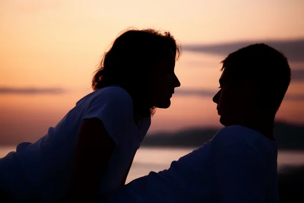 Siluett man och kvinna på strand — Stockfoto