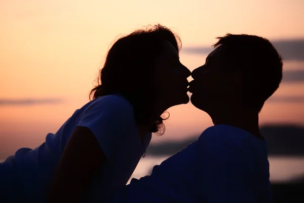 Silhouette kysser man och kvinna på strand — Stockfoto