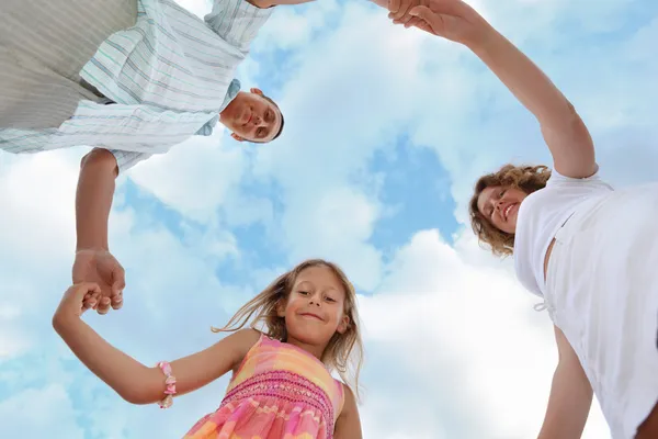 Happy family with little girl against sky, foreshortening from b — Stock Photo, Image