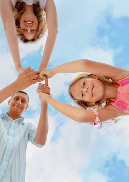 Familia feliz con niña contra el cielo, escorzo de b —  Fotos de Stock