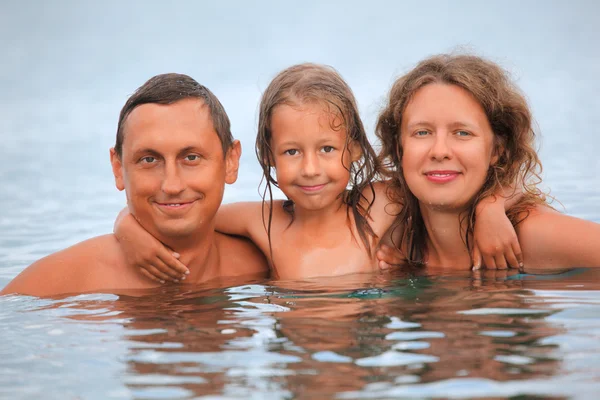 Lycklig familj med liten flicka bada i havet — Stockfoto
