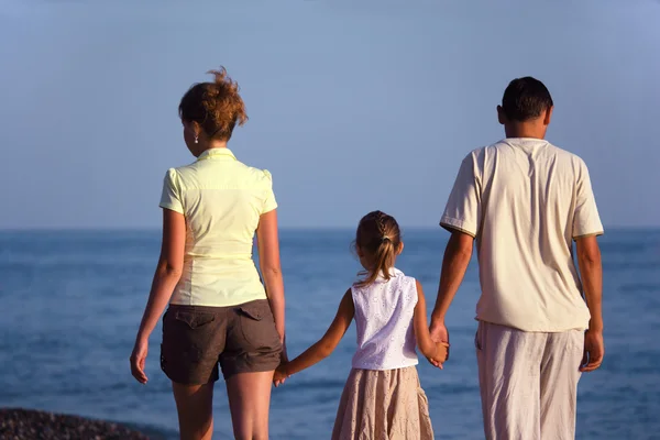 Family with girl walks along sea beach — Stock Photo, Image