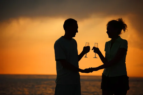 Erkek ve kadın deniz günbatımı gözlüklerle Silhouettes — Stok fotoğraf