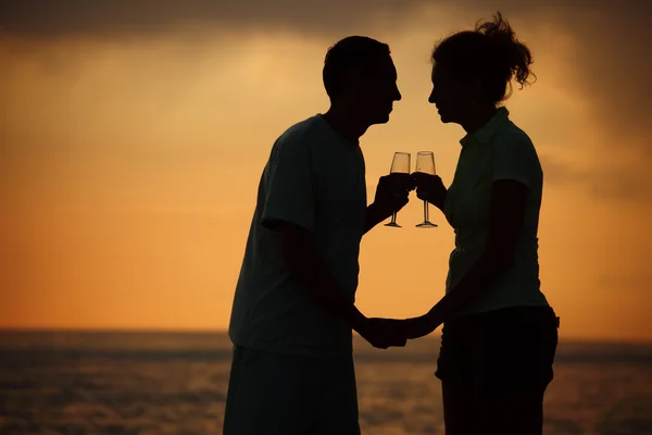Silhuetas de homem e mulher com óculos no pôr do sol do mar — Fotografia de Stock