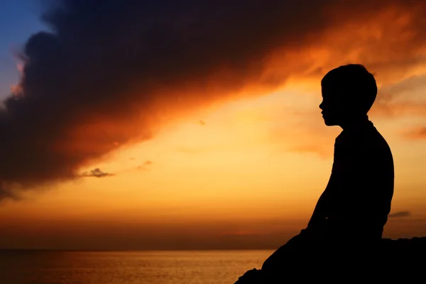 Silhouette del ragazzo sul tramonto del mare — Foto Stock