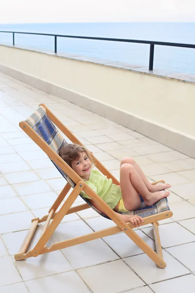 Kleines Mädchen in der Lounge auf der Veranda — Stockfoto