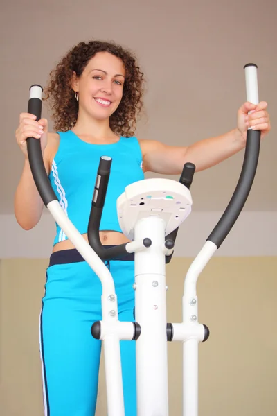 Smiling young woman on training apparatus — Stock Photo, Image
