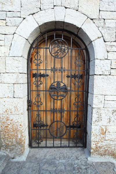 Door behind lattice in stone wall