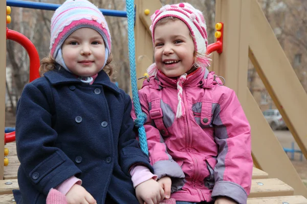 Две улыбающиеся девушки на детской площадке — стоковое фото