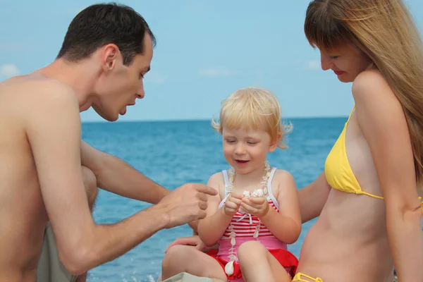 Rodiče s dítětem na břehu moře — Stock fotografie