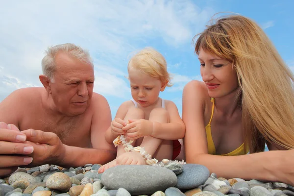 Мать с дедушкой и маленькой девочкой на пляже, широкий угол — стоковое фото