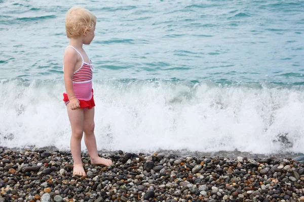 Ребенок стоит на галечном пляже — стоковое фото