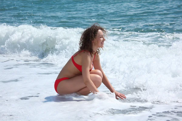 Güzellik kız deniz dalgaların arasında oturur — Stok fotoğraf